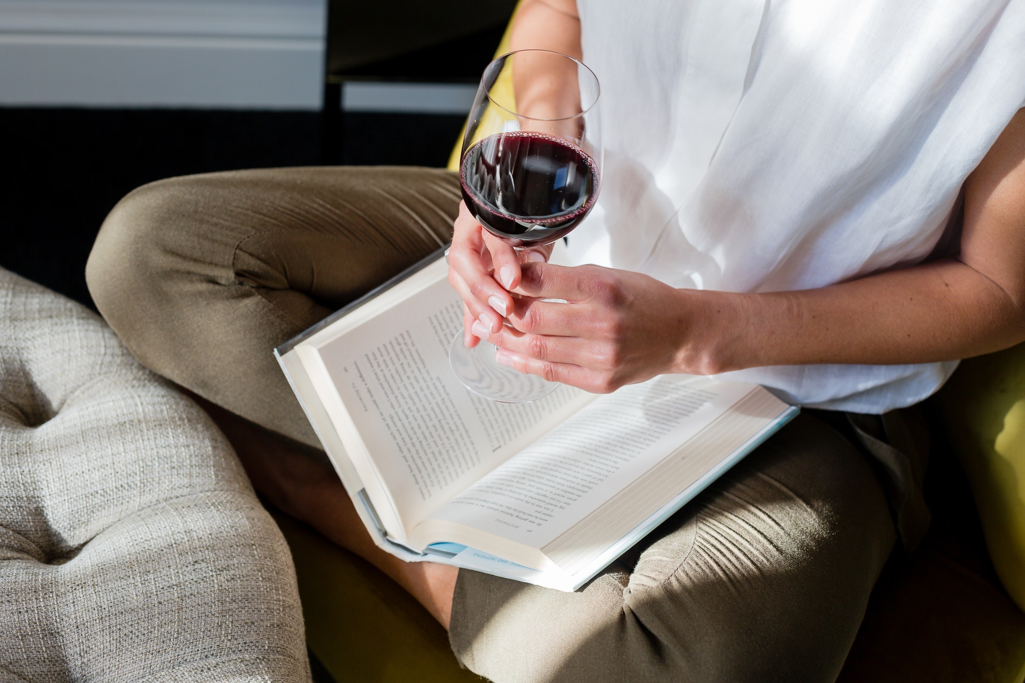 Mujer leyendo con una copa de vino